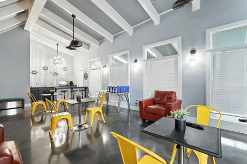 A dining room with a black table and yellow chairs.