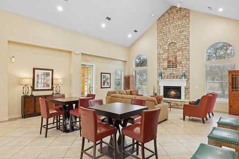 A large dining room with a fireplace and a brick wall.