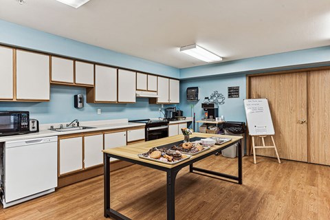 A kitchen with a table in the middle of it.