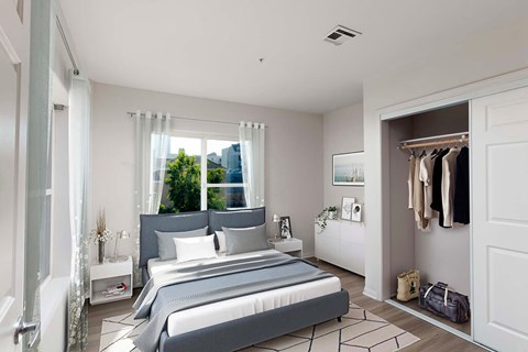 A bedroom with a large bed and a window with a view of the city.