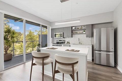 A modern kitchen with white cabinets and a large island.