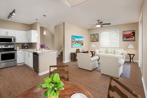 A well-lit, spacious kitchen and living room with a dining table and chairs.