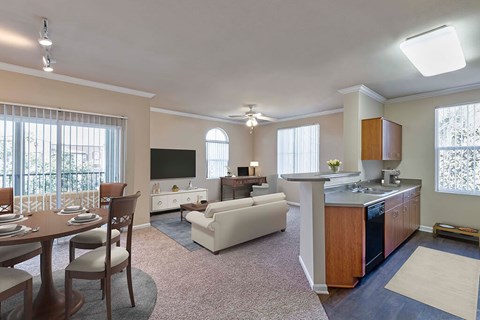 A well-lit, spacious kitchen and living room with a dining table set for four.