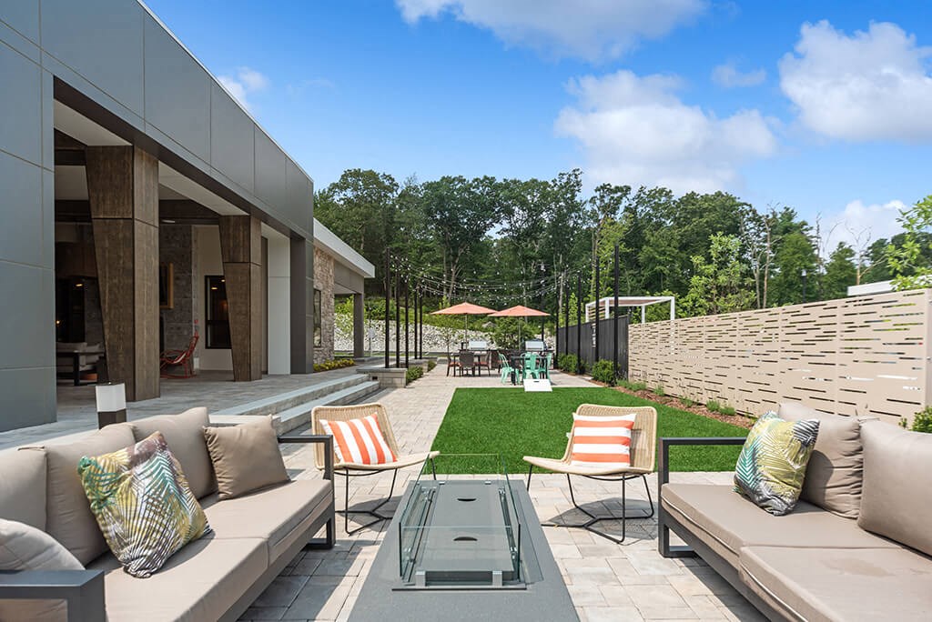 Sun deck with fire pit and corn hole at The Quill Apartments in Milford MA