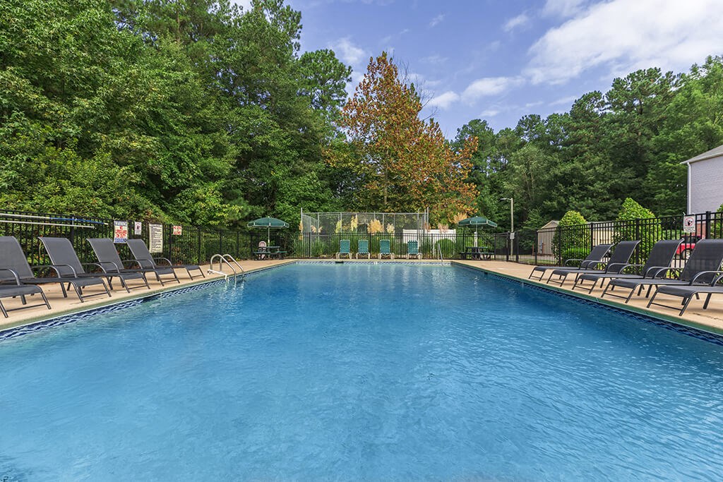 Pool surrounded by landscaping at Greens of Pine Glen in Durham NC