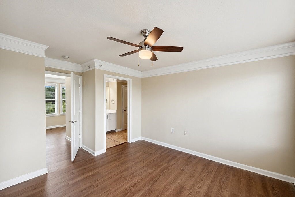 an empty living room with a ceiling fan