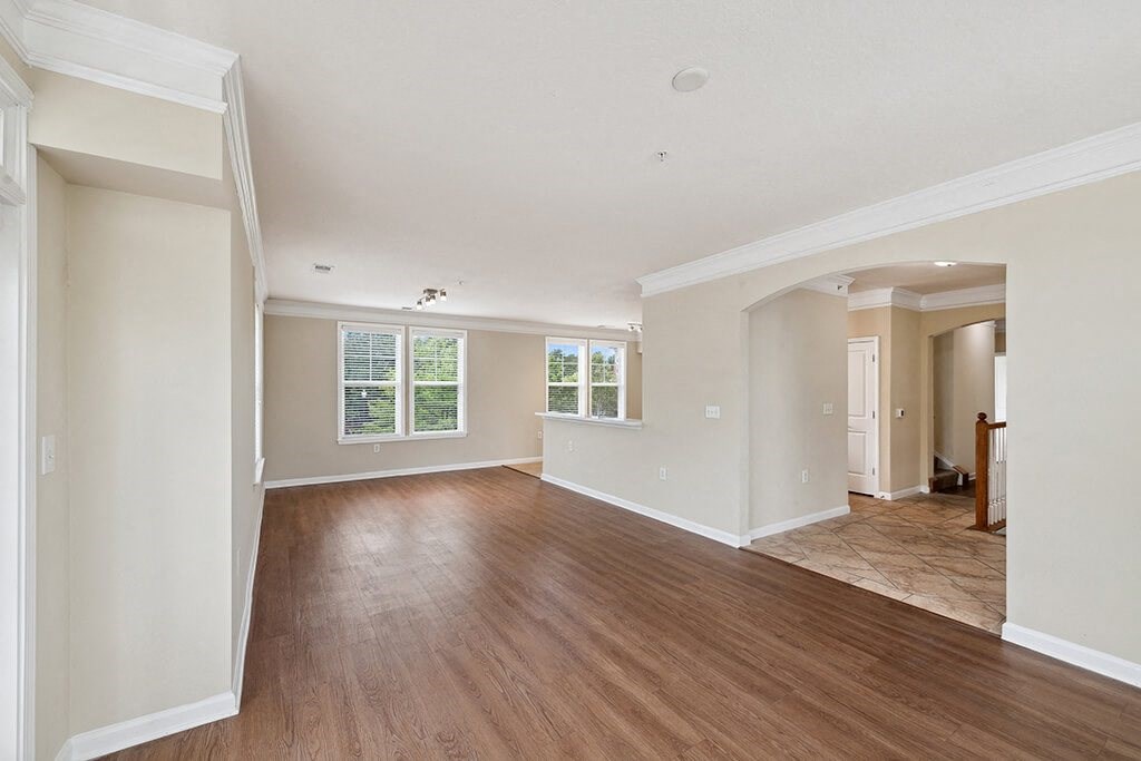 the living room and dining room of an empty house with wood floors
