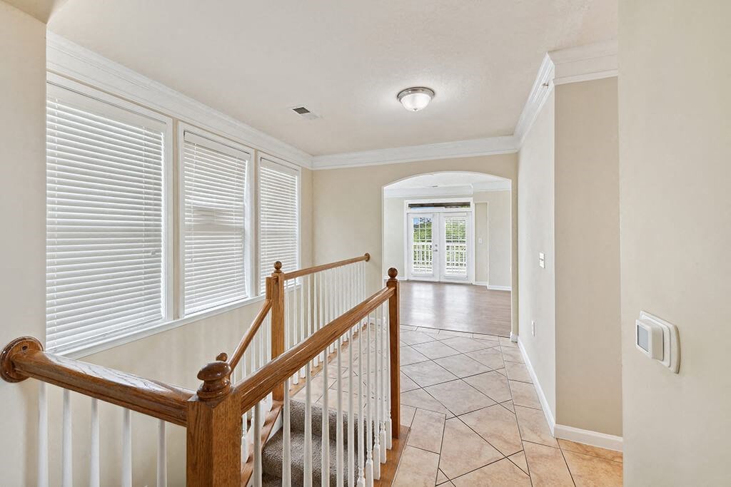 a view of a staircase and a hallway with a large window