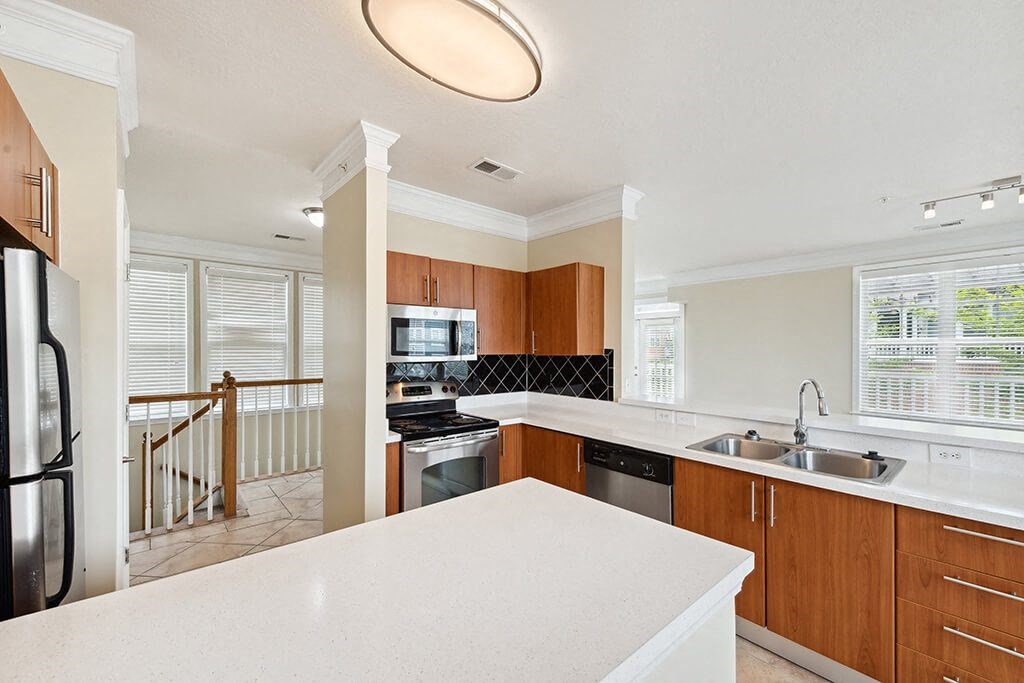 a kitchen with a white counter top and a sink