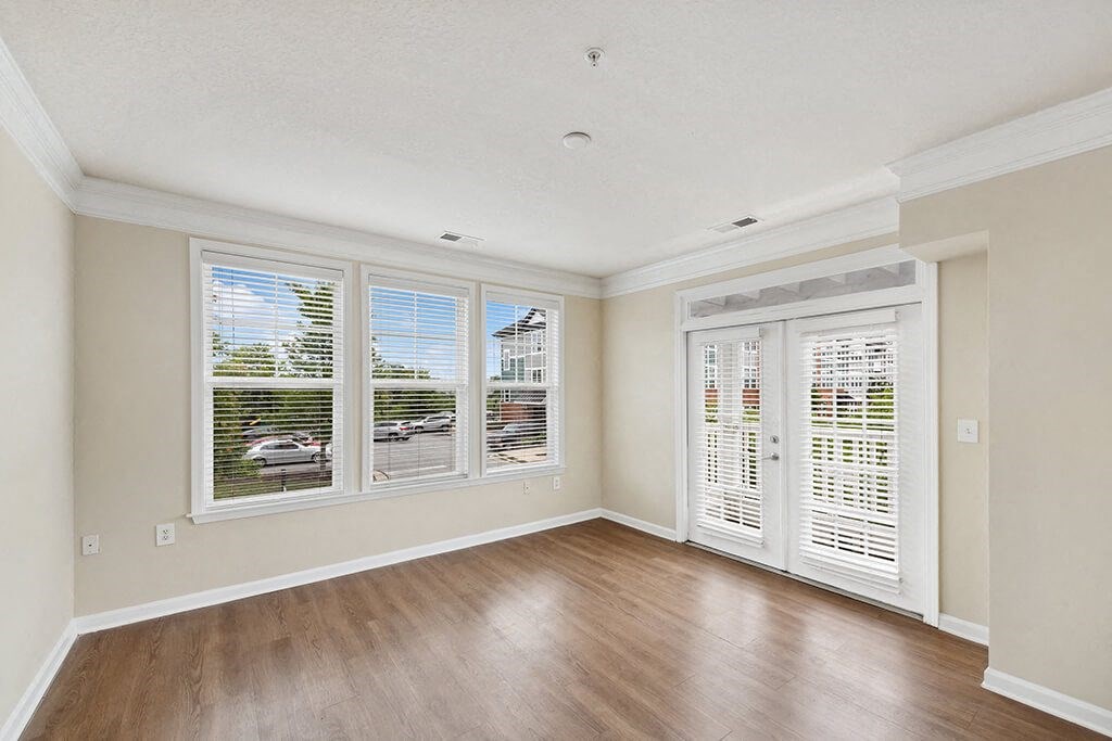 a living room with a hard wood floor and large windows