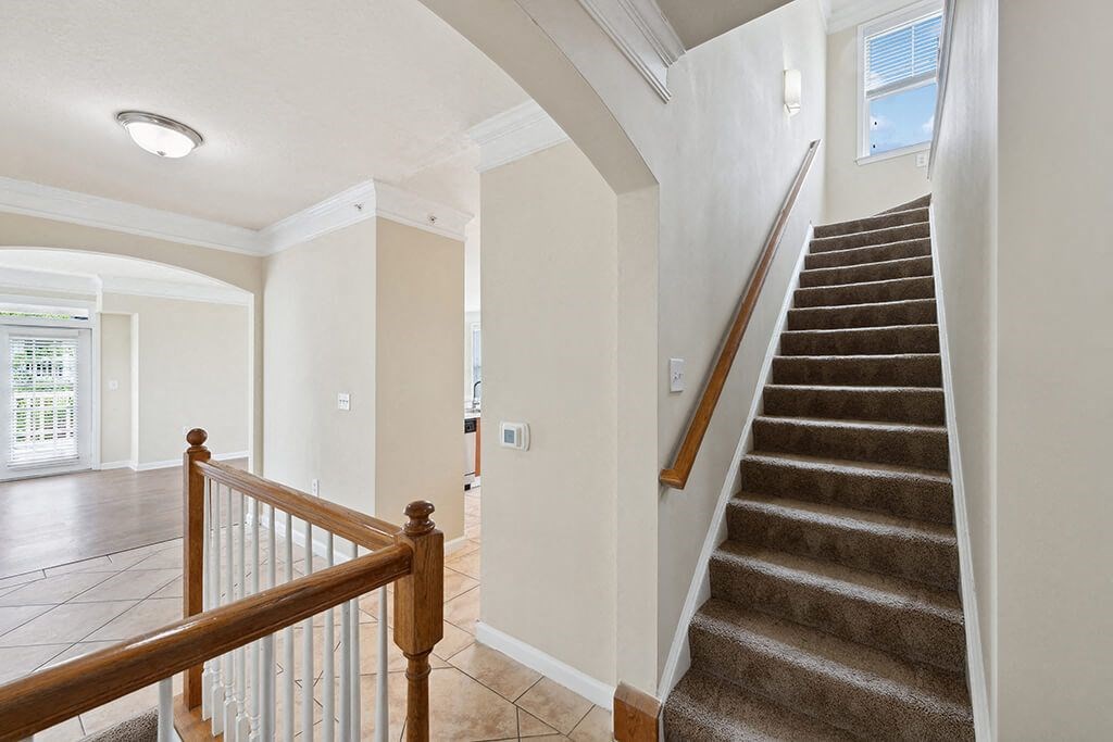 a staircase in a home with a door to a hallway and