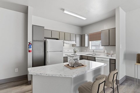 A kitchen with a white counter top and stainless steel appliances.