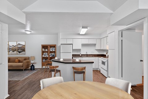 A modern kitchen with a dining table and chairs.