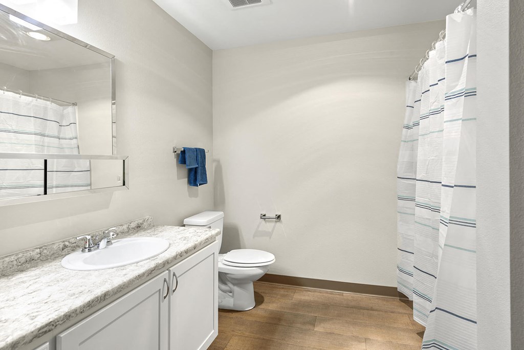 Federal Way Apartments - Meridian Court - Large Mirror, Grey Countertops, and Wood-Style Floors