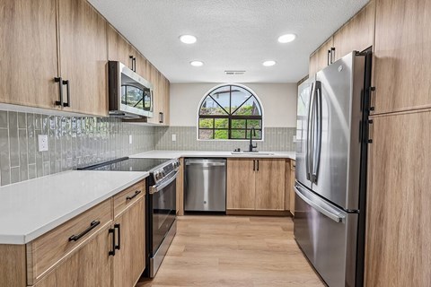 A kitchen with wooden cabinets and stainless steel appliances.