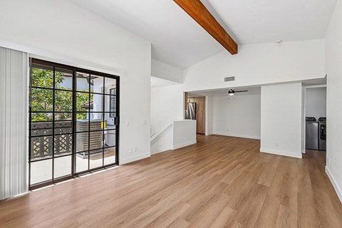 A spacious room with wooden floors and white walls.