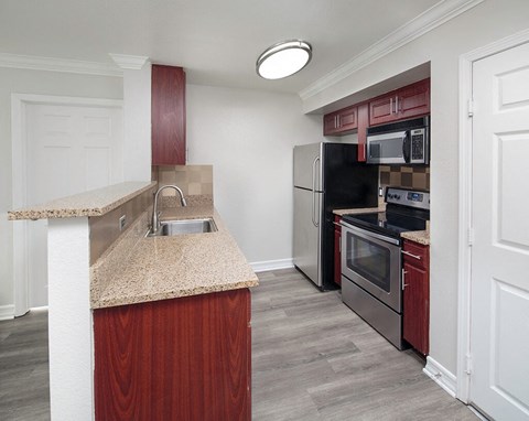 a kitchen with granite counter top and stainless steel appliances
