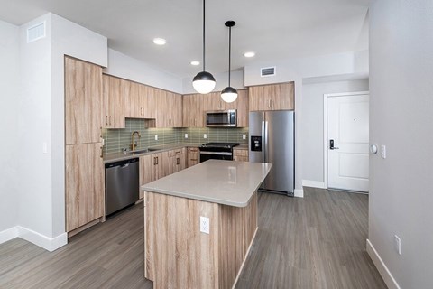 A modern kitchen with wooden cabinets and stainless steel appliances.