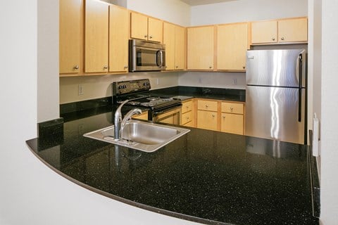 a kitchen with a black counter top and a sink