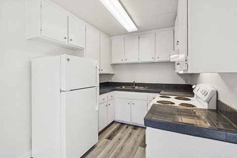A kitchen with white appliances and cabinets.