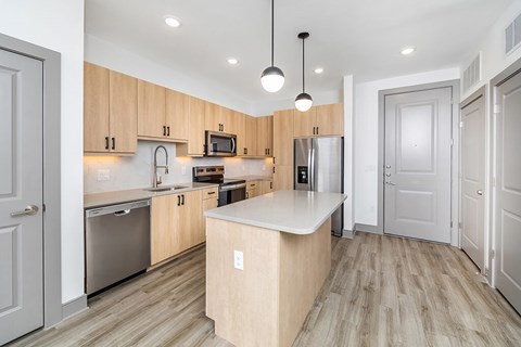A kitchen with wooden cabinets and a white island.