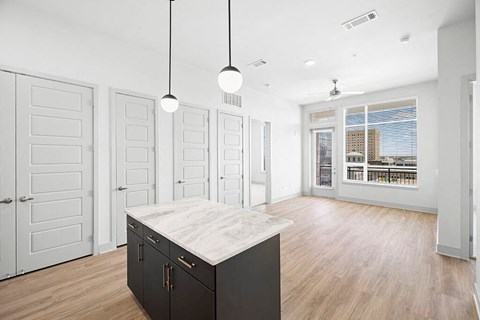 Penthouse Design Package Kitchen Island and Living Room at 1810 Main Apartments in Houston TX