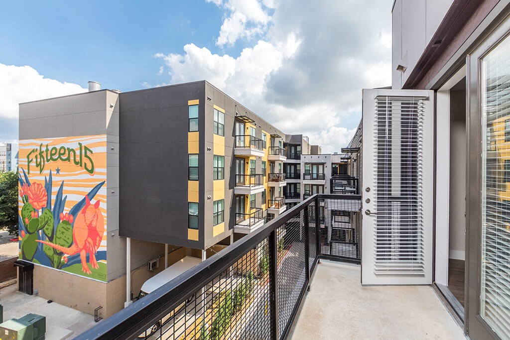 a balcony with a view of some buildings and a colorful mural