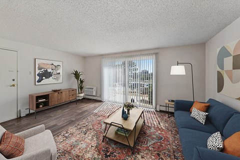 a living room with a blue couch and a sliding glass door