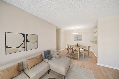 A living room with a couch, a table, and a painting on the wall.