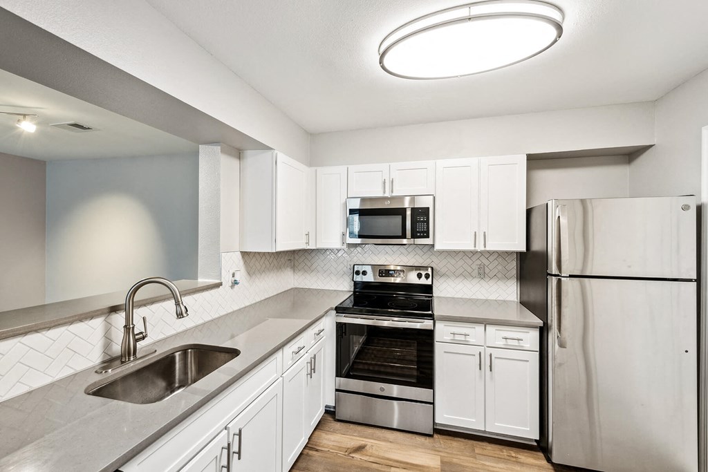 Kitchen with fridge and white cabinets at England Run Apartments in Fredericksburg VA