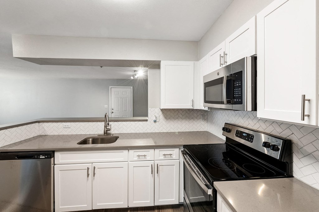 Kitchen with white cabinets and oven at England Run Apartments in Fredericksburg VA