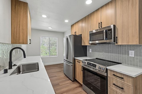 A modern kitchen with wooden cabinets and stainless steel appliances.
