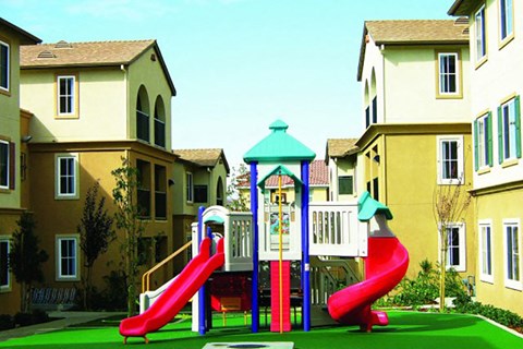 a playground with two slides and a house