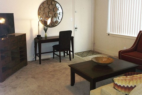 a living room with a desk and a chair