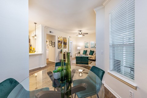 a living room and dining room with a glass table and chairs