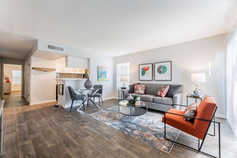 a living room with a couch and a chair and a kitchen