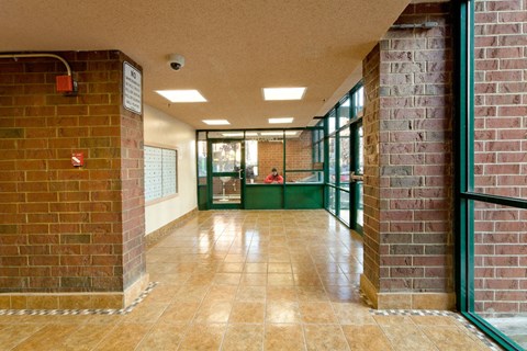 A long hallway with brick walls and tile flooring.