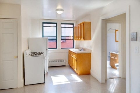A kitchen with white appliances and wooden cabinets.
