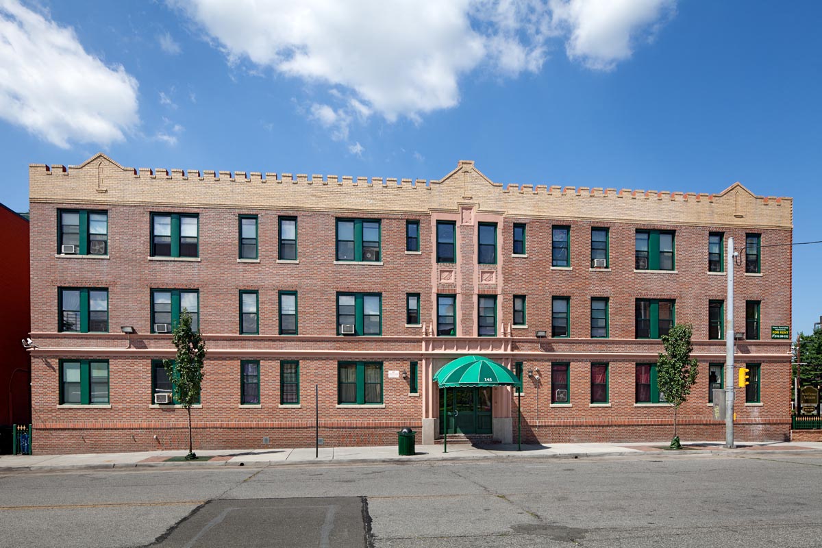 A red brick building with green awnings.