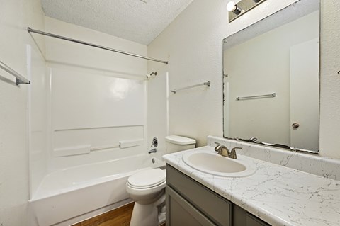 A white toilet sits next to a sink in a bathroom.