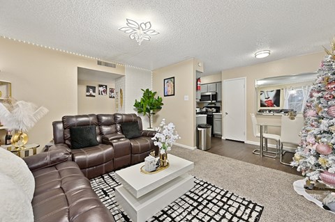 A living room with a brown leather couch and a white coffee table.