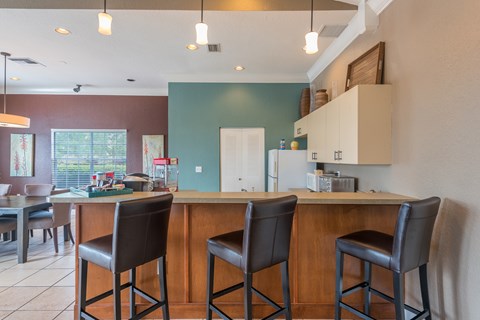 A kitchen with a bar area and two chairs.