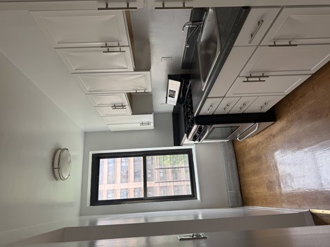 A kitchen with a window and a stainless steel counter.