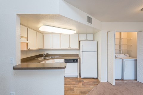 A kitchen with white cabinets and a white refrigerator.
