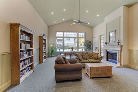 A living room with a fireplace, couches, and a bookshelf.