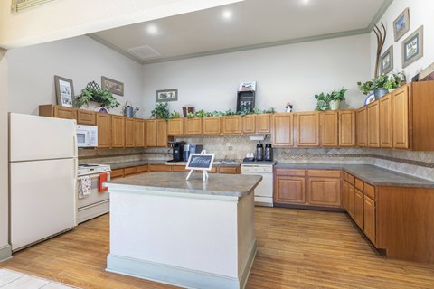 A kitchen with wooden cabinets and a white island.