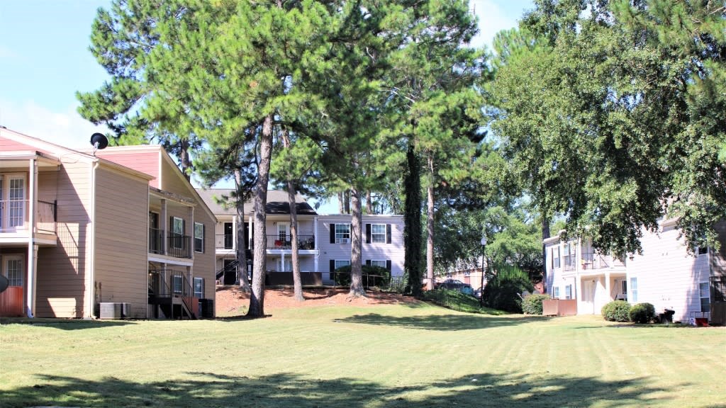 A row of houses with trees in front of them at Clarkston Station Apartments, Clarkston