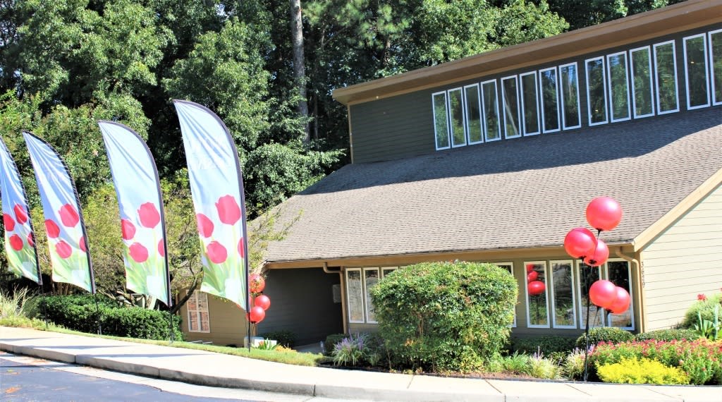 A house with a green lawn and a flag with red dots at Clarkston Station Apartments, Clarkston, 30021