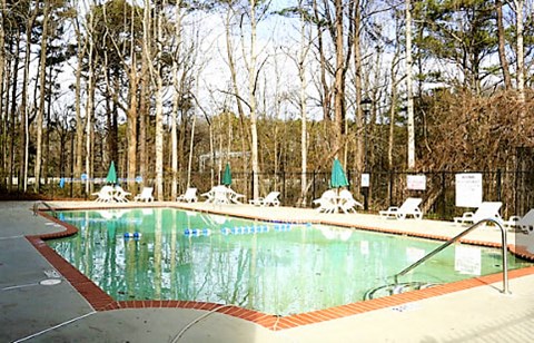 a swimming pool with chairs and umbrellas