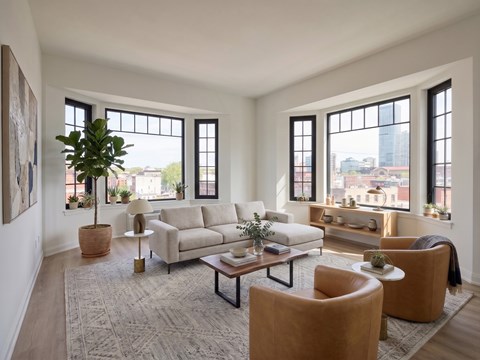 A living room with a large window and a view of the city.